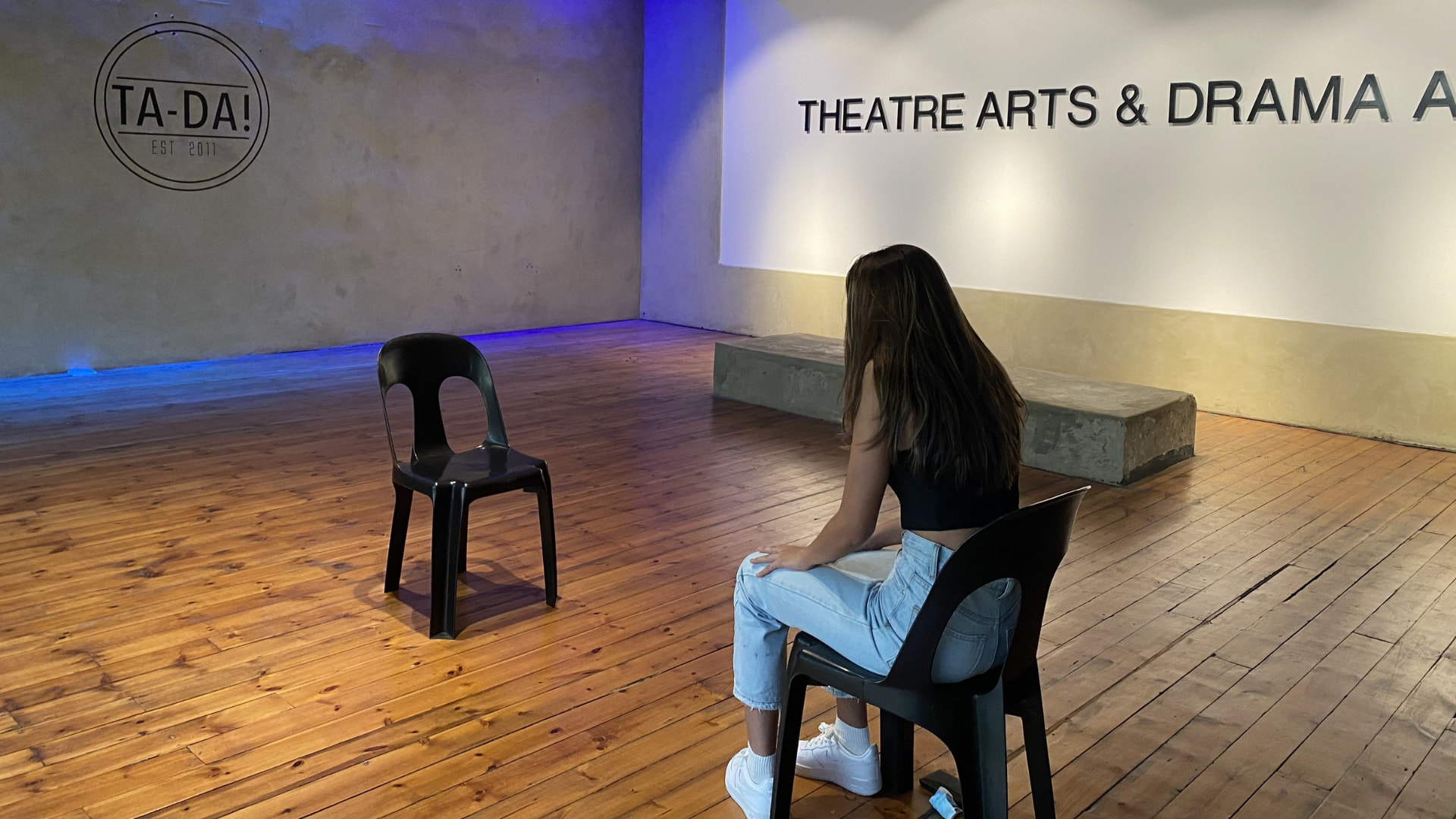 A student sitting facing an empty chair in the TA-DA! studio