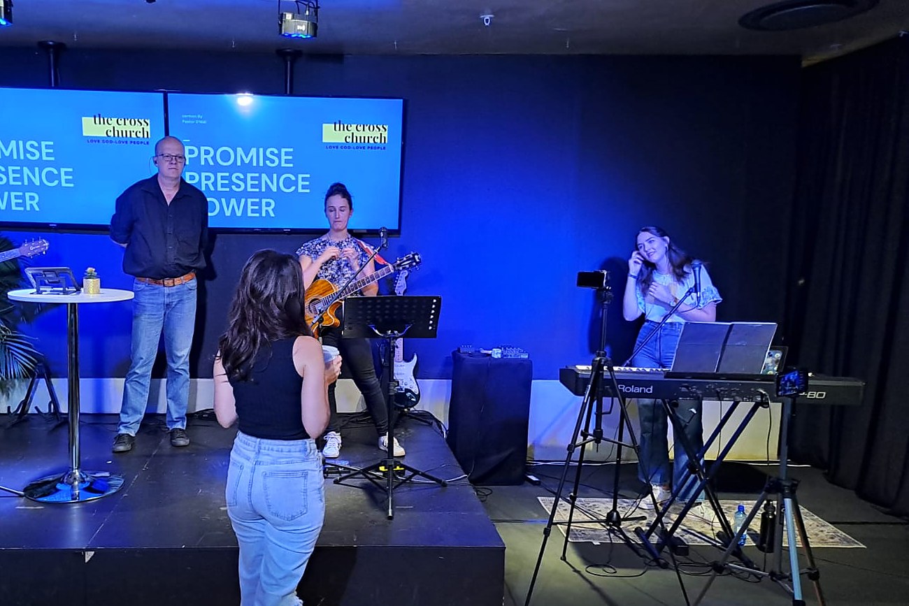 D'Niël coaching a worship team on stage