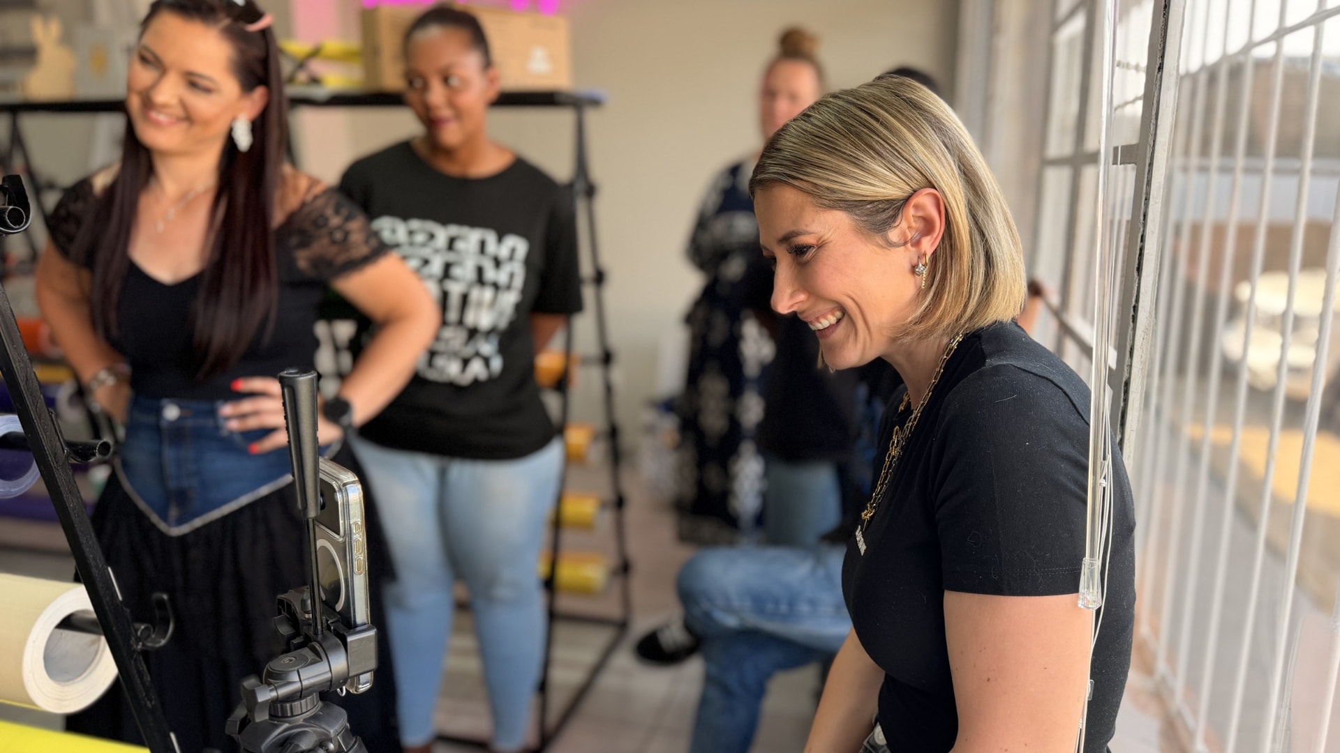 Danielle Steynvaardt laughing with students around a camera during a creator workshop